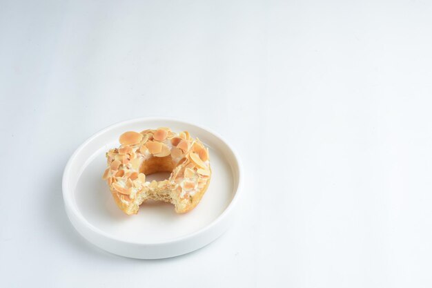 bitten donuts in white plate topped with green tea and almond slices