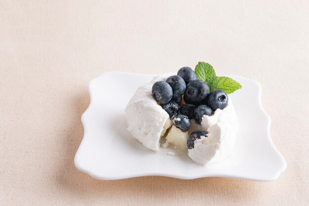 Bitten homemade delicious meringue cake with fresh blueberries.