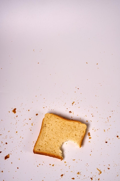 Bitten slice of toast bread on a white isolated background.