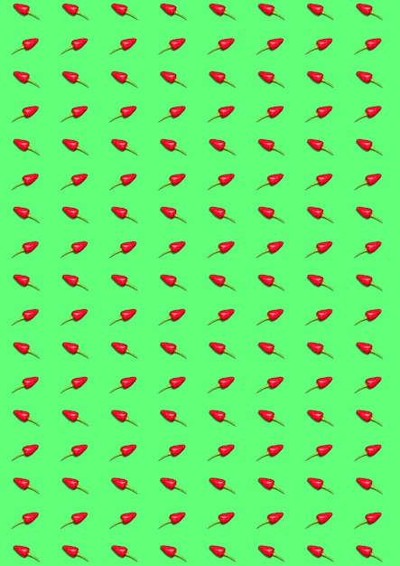 The bitter chili pepper and paprika on a green background. The abstract pattern background.