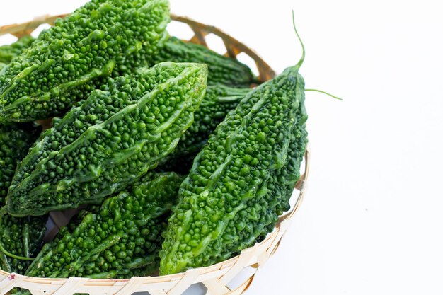 Bitter gourd in bamboo basket on white background.