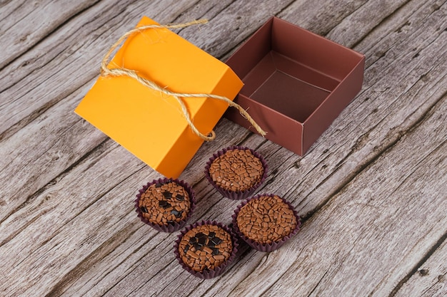 Bitter and traditional brigadeiros next to an open box Brazilian traditional sweet