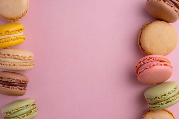 Bitterkoekjes kleurrijke koekjes macarons frans zoet dessert bovenaanzicht roze achtergrond kopieer ruimte