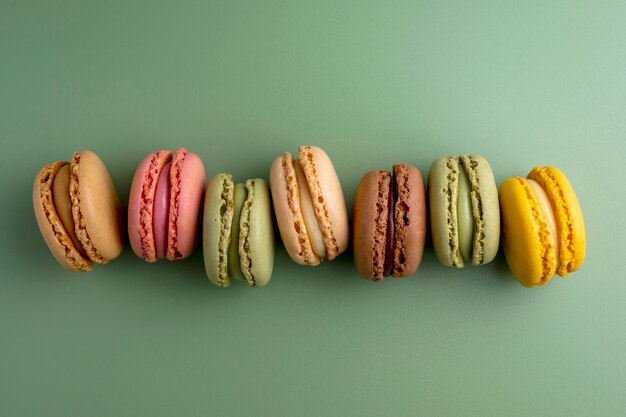 Bitterkoekjes kleurrijke koekjes Macarons in kom frans zoet dessert bovenaanzicht groene achtergrond Kopieer ruimte