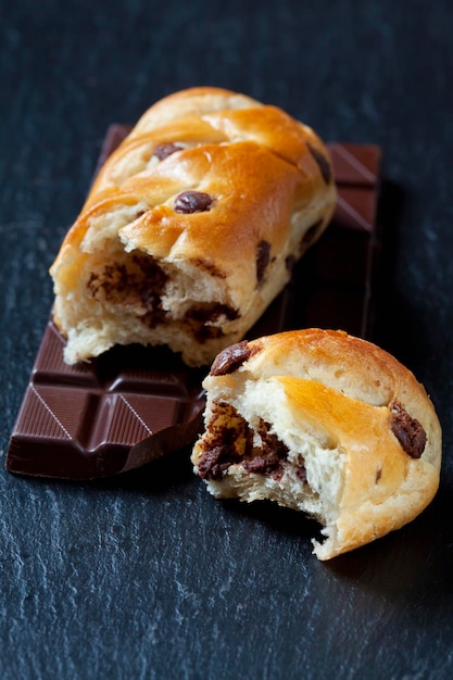 Bittersweet chocolate bar and chocolate bun on slate