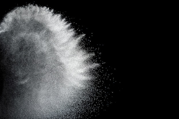 暗い背景に対する白い粉の爆発の奇妙な形。白い粒子を発売