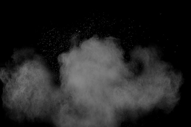 Bizarre vormen van de witte wolk van de poederexplosie tegen zwarte achtergrond. De witte stofdeeltjes bespatten.