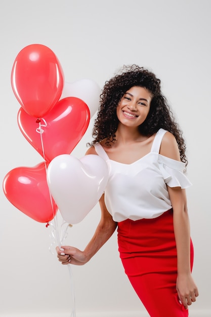 Photo bkack woman with colorful red heart shaped balloons isolated