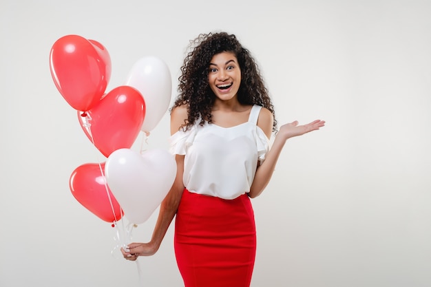 Photo bkack woman with colorful red heart shaped balloons isolated