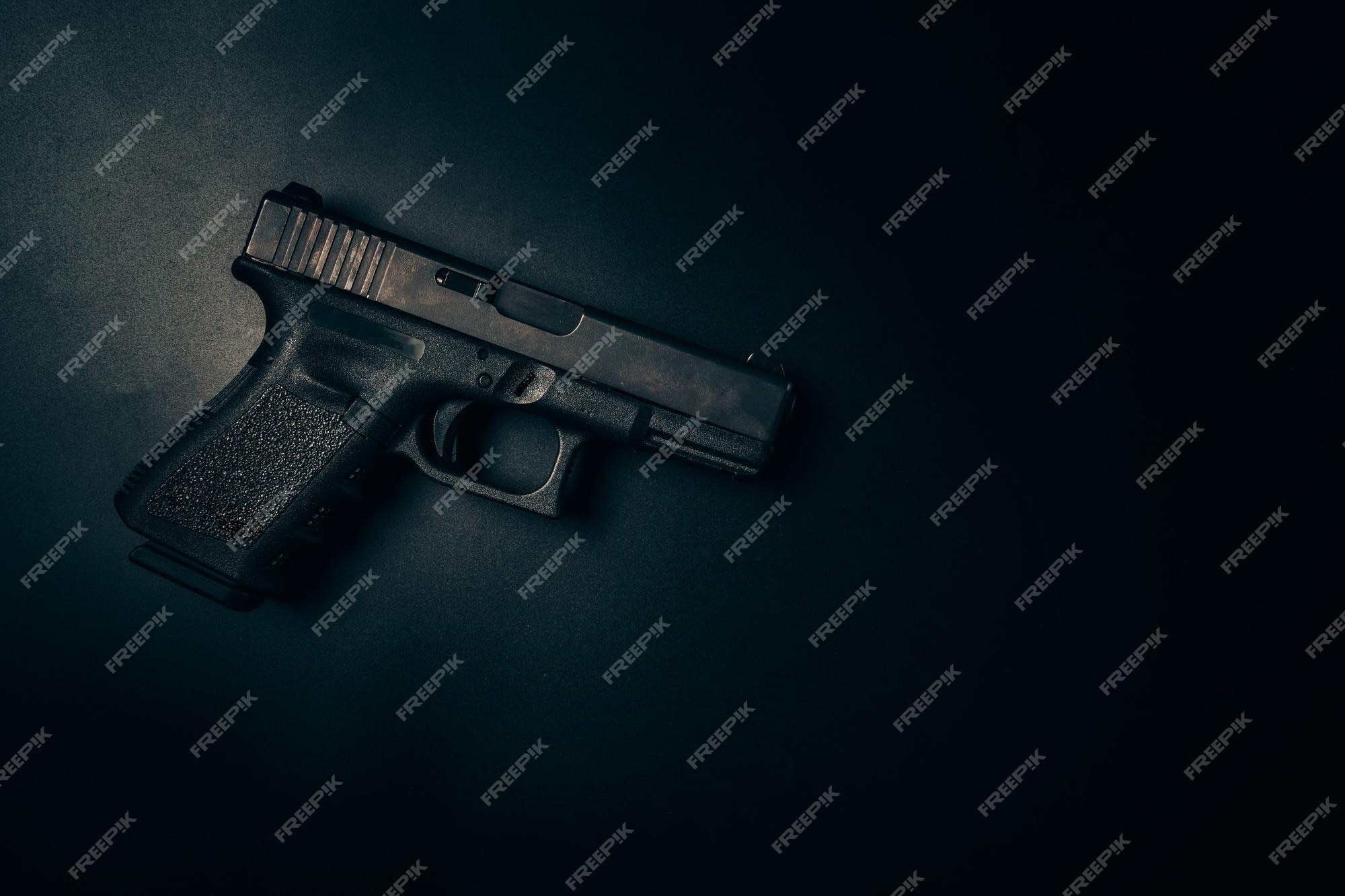 Premium Photo | Black 9mm pistol on black background top view