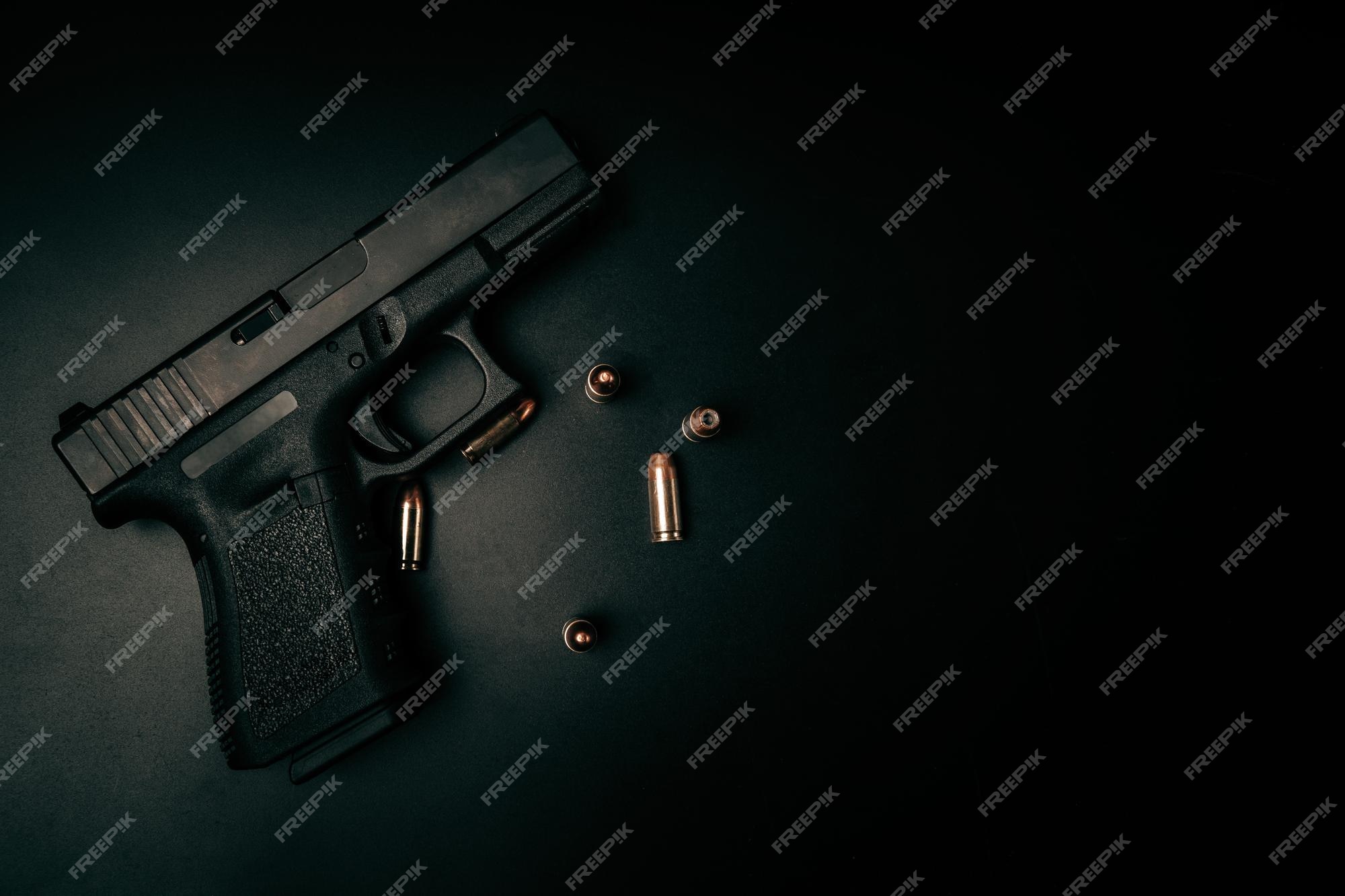 Premium Photo | A black 9mm pistol on a black background with 9mm  ammunition next to it top view