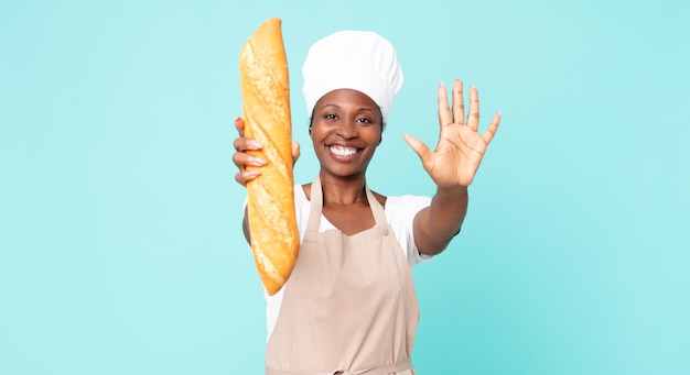Black african american adult chef woman holding a bread baguette