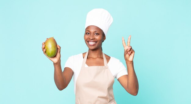 Black african american adult chef woman hwith a mango