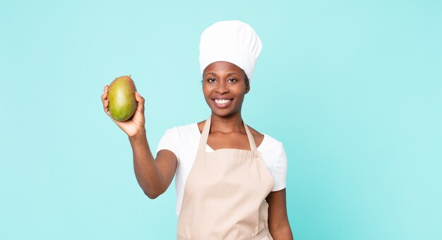 black african american adult chef woman hwith a mango