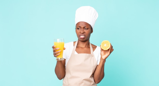 Black african american adult chef woman . orange juice concept