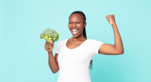 Black african american adult woman holding a broccoli