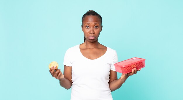 Black african american adult woman holding a tupperware