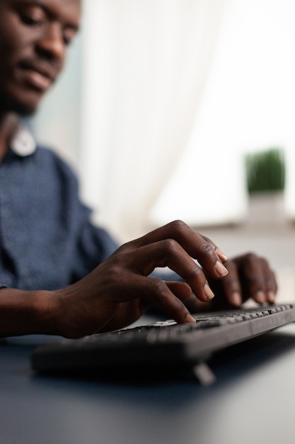 Black african american person typing on pc keyboard