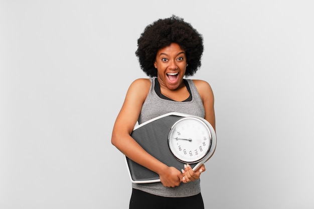 Black afro fitness woman with a balance or scale