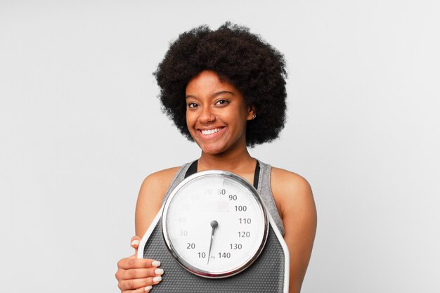 Черная афро-фитнес-женщина с балансом или весами