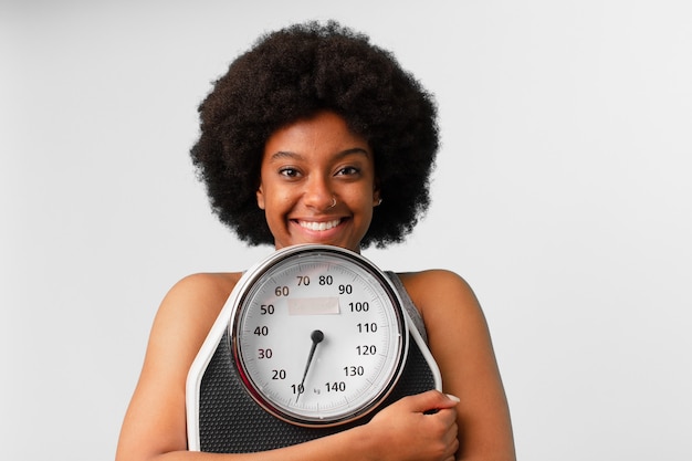 Black afro fitness woman with a balance or scale