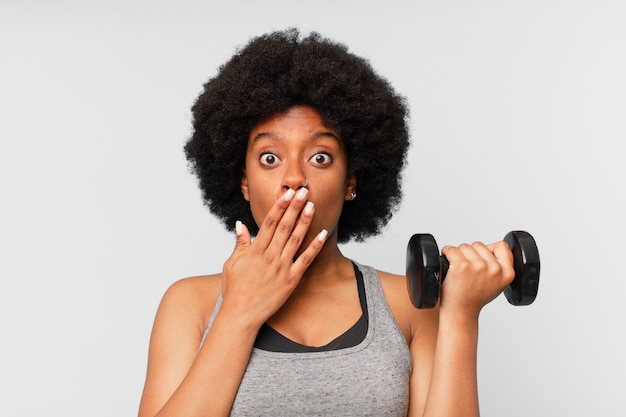 Black afro fitness woman with a dumbbell