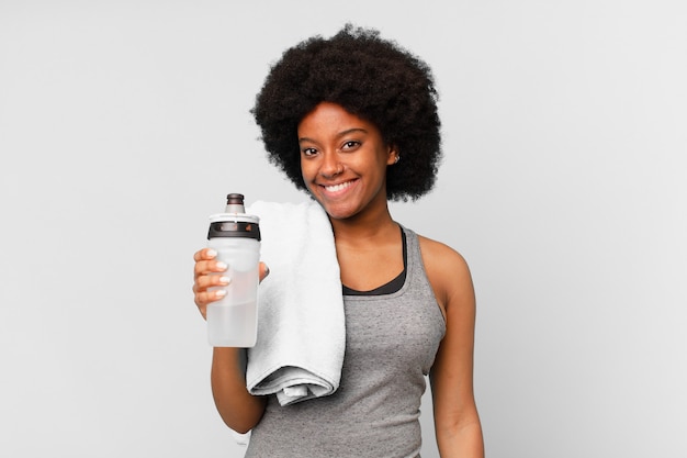 Черная афро-фитнес-женщина с полотенцем и водой
