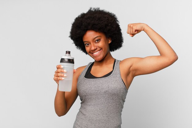 Black afro fitness woman with a towel and water can