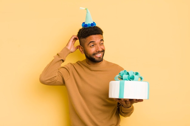 Black afro man smiling happily and daydreaming or doubting birthday concept