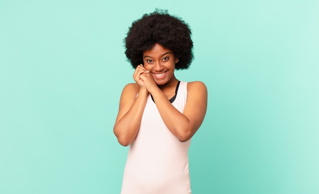 Black afro woman against isolated wall