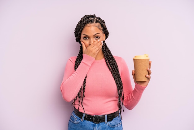 충격을 받은 손으로 입을 덮고 있는 흑인 아프리카 여성. 커피를 테이크 아웃