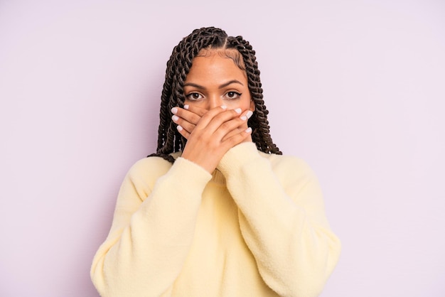 Donna afro nera che copre la bocca con le mani con uno shock