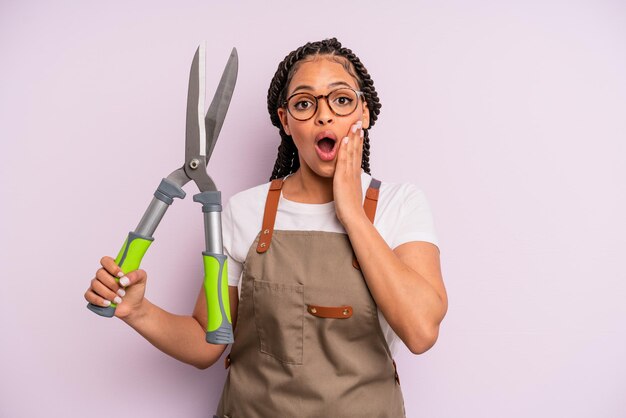 Donna afro nera che si sente scioccata e spaventata. concetto di giardiniere o agricoltore