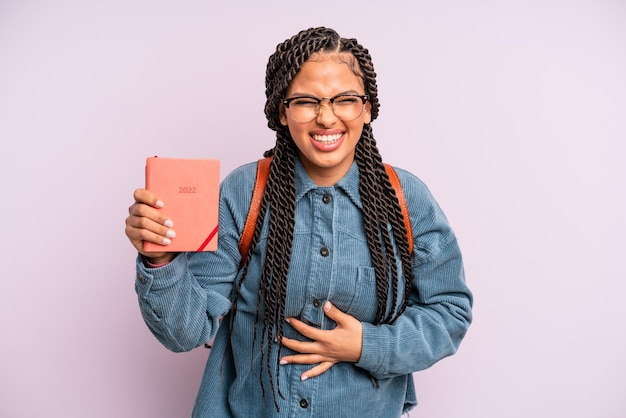 Black afro woman laughing out loud at some hilarious joke.\
student calendar or agenda concept