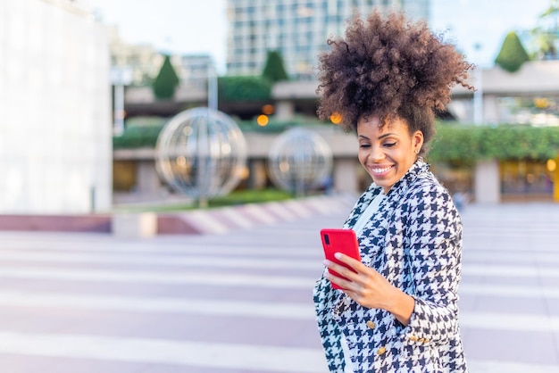 전화를 행복하게 보고 있는 흑인 아프리카 여성