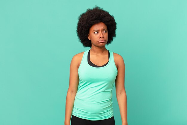 Black afro woman looking puzzled and confused wondering or trying to solve a problem or thinking