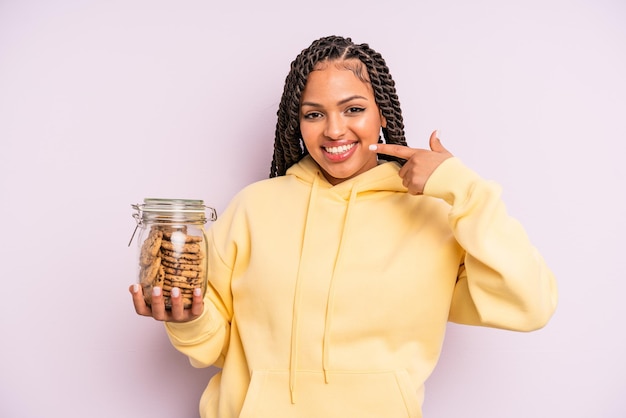 Black afro woman smiling confidently pointing to own broad smile. cookies concept