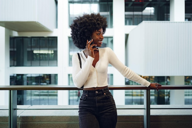 Black afro woman talking on mobile phone in the city