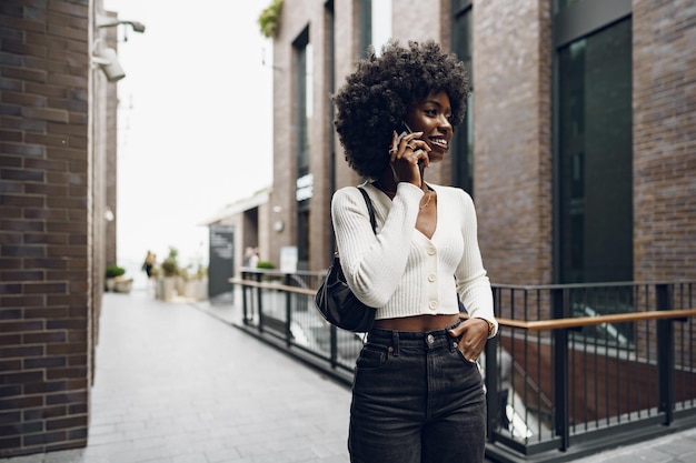 市内の携帯電話で話している黒人アフロ女性