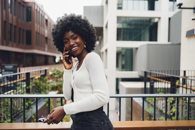 Black afro woman talking on mobile phone in the city