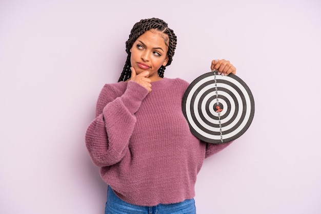 Black afro woman thinking, feeling doubtful and confused. target dart concept