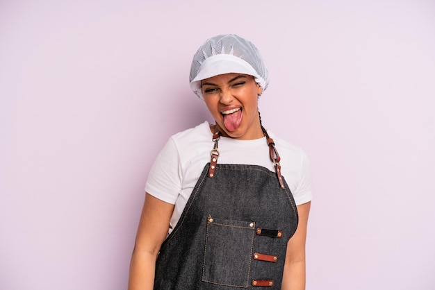 Black afro woman with cheerful and rebellious attitude joking and sticking tongue out fishmonger concept