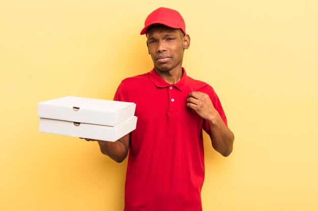 Black afro young man looking arrogant successful positive and proud pizza delivery man concept