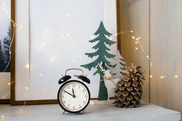 Black alarm clock and pine cone with lights