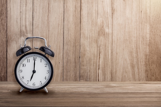 black alarm clock on wooden background