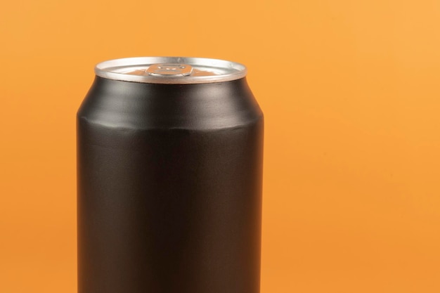 Black aluminum can isolated on orange background