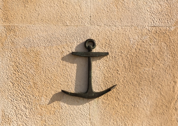 Photo black anchor on the stone wall