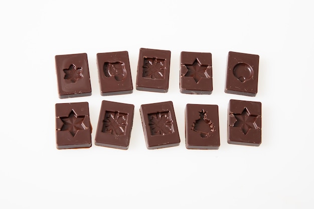 Black artisanal chocolate candies in flat top view white background