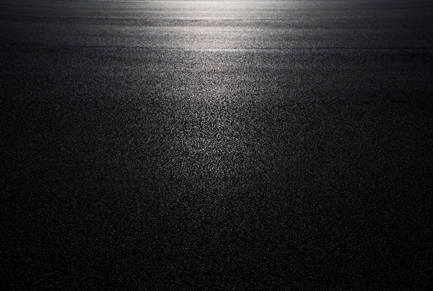 A black asphalt background surface with a light at the top