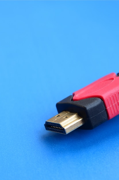 Black audio video HDMI computer cable on blue background